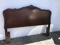 Full view of the solid wood queen size headboard with carved detailing and curved top edge.