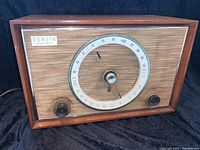 Front view of the Zenith 8C01 radio showing the wooden case and fabric front panel with tuning dial and knobs.