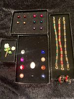 Full layout of the jewelry showing bracelets, earrings, interchangeable stones, and brooch