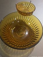 Top-down view of large amber chip bowl with attached smaller dip bowl, showing detailed diamond pattern and sunburst center.