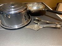 Photo showing cake carrier with dome lid (close view) along with tray with center bowl, pie server and tongs.