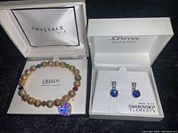 Photo of the two jewelry items in their display boxes: blue Swarovski earrings in JCPenney Sterling Silver box, and Crystale Swarovski Elements bracelet in Crystale branded box.