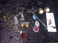 Photo of the entire lot showing all jewelry items on black fabric background.