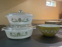 Photo showing two Glasbake Primrose Dream covered casseroles stacked and Pyrex Crazy Daisy mixing bowl beside them