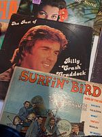Photo showing The Best of Billy 'Crash' Craddock and Surfin' Bird by The Trashmen LPs along with other albums.