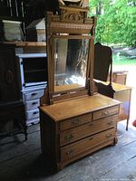 Front perspective of dresser with attached ornate mirror