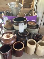 Photo showing a variety of vintage glazed crockery, including a large bean pot, smaller jars, and a cheese pot with a lid and metal handle.