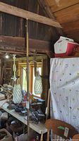 Full view of the tall floor to ceiling lamp with two hanging glass light shades, brass finish, in attic setting.