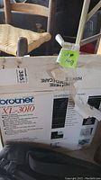 Box of Brother XL-3010 free arm sewing machine showing partial product name and some quality features.