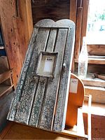 Front view of wood medicine cabinet showing crackled paint finish, scalloped top edge, small wood pull, and inset window on door.