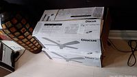 Original packaging box for Monte Carlo Discus 52 inch ceiling fan showing model 5D152RBD-L with product image and specifications.