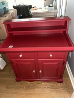 Front view of red manufactured wood dry sink showing drawers and cabinet doors