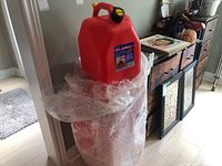Photo of stacked red plastic fuel cans wrapped in bubble wrap showing original packaging.