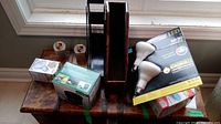 Overview photo showing all items in the lot including light bulbs, desk organizers, and inflator box