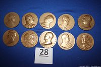 Photo showing 10 bronze medallions with raised profiles of U.S. presidents Hoover to Reagan arranged in two rows on a blue background, with a label numbered 28.