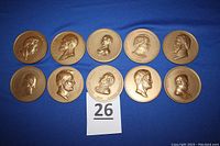 Ten bronze medallions laid out on blue background, all with profile portraits of U.S. presidents from James K. Polk to James Garfield.