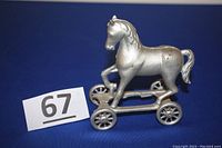 Silver painted cast iron horse on wheels still bank, front view with lot number.