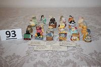 Photo showing all 24 different Lenox porcelain cat thimbles arranged in rows with lot number card and labels