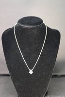 Full view of sterling silver necklace with pendant on display bust