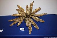 Top view of mid-century brass metal fern sculpture displaying the multiple fern leaves radiating from the center.