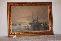 Full view of framed oil painting showing two sailboats and fishermen on shore with tide.
