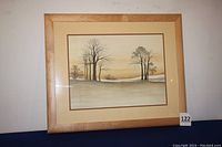 Full view of the framed print on a white wall showing the overall light wooden frame and matting.