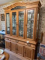 Full view of the solid oak china cabinet showing four beveled glass doors, three drawers below and four wood doors at the bottom.