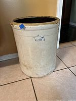 Front view of the large off-white stoneware crock with blue crown mark on front.