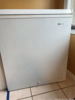 Front and side view of white Haier chest freezer showing overall condition and dimensions.
