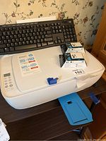 HP Deskjet 3630 all-in-one printer with two ink cartridges placed on top and a small control panel visible.