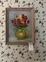 Painting of tulips in golden vase signed by Maks Knispel, framed in wood, against floral wallpaper.