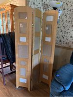 Full view of three-panel wooden photograph screen with rectangular glass sections for photos, positioned near furniture in living space.