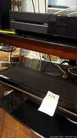 Side angle close-up of Xbox console showing Xbox logo and some dust.