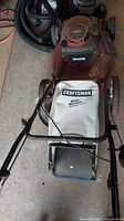 Top front view of red Craftsman gas push lawn mower featuring white Dust Blocker bag and black handlebar, showing wear and dirt.