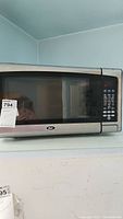 Front view of Oster microwave showing control panel and glass door