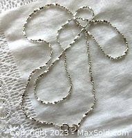 Image showing the full length of the sterling silver twisted sparkle diamond cut chain laid out with details visible of the twisted and faceted pattern.