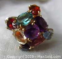 Cluster of multi-colored faceted gemstones set in prongs