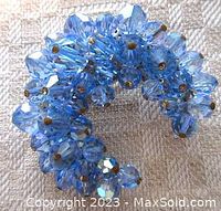 Front view of vintage brooch with clustered baby blue faceted glass beads attached to metal base