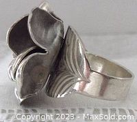 Side angle showing the large sculpted flower petals and the engraved leaf pattern on the band.