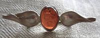 Front view showing the amber cabochon center flanked by two leaf-shaped silver components.