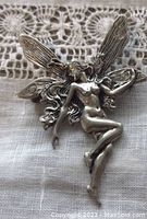 Front view of detailed sterling silver fairy woman brooch showing polished finish and intricate wing engraving
