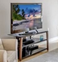 Photo of the 46-inch Toshiba TV on a stand with black tempered glass shelves. Includes Toshiba Blu Ray player on the middle shelf and a small candle on the bottom shelf.