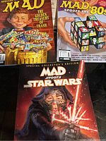 Photo showing three Mad Magazine compendiums with colorful illustrated covers and titles.