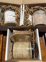 Set of bath salts and soaps in packaging with shredded paper filler in cardboard box.
