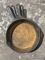 Top-down photo of one cast iron skillet showing rust, patina, handle with hole, and dual-pour spout