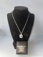 Full front view of the necklace on a black velvet display bust with the Gold Coast jewelers box in front.