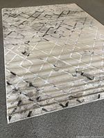 Photo showing the full rug laid flat on a carpeted floor, highlighting size and geometric pattern.