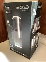 Front and side of the black box showing the Artika Linea LED wall light with product details and image of the light.