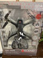 Front view of the drone in original sealed packaging showing drone and controller with specifications and branding