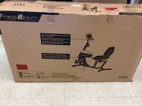 Cardboard box with illustration and brand name Fitness Reality, showing the recumbent bike and computer display features.